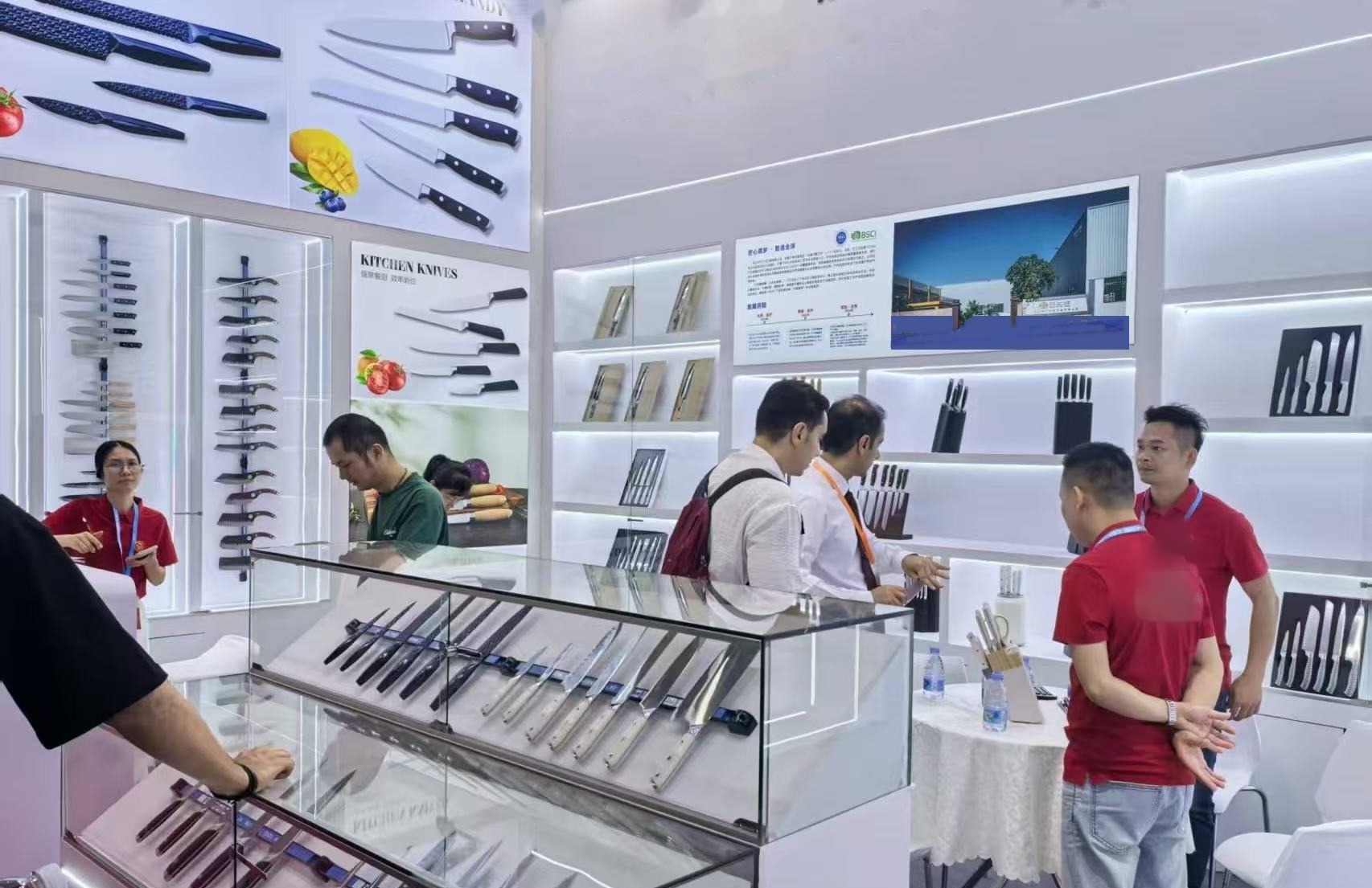 Buyers comparing knives at the booth's glass counters