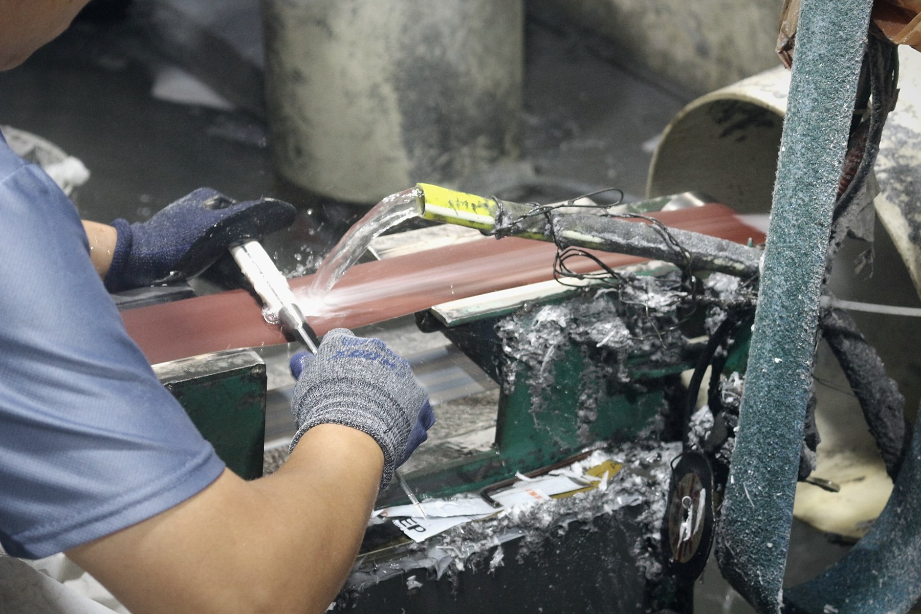 Wet-belt grinding sets the bevel on a blade at the Yangjiang plant